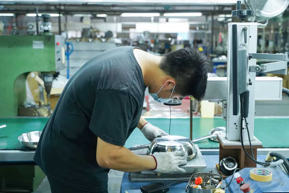 Stainless steel cookware sample inspection with caliper, scale and specification sheet